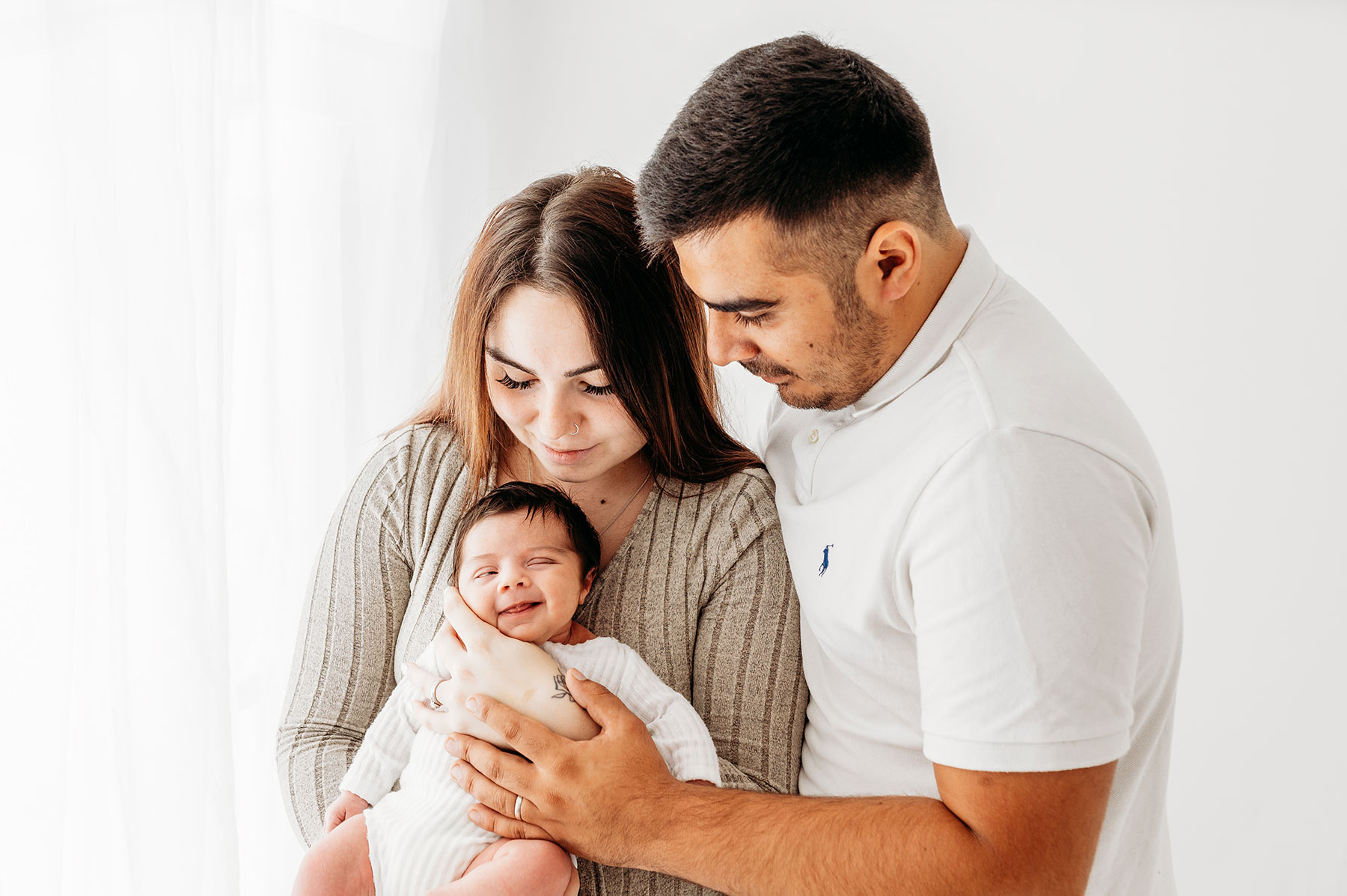 Kent newborn photoshoot- Mum & dad holding baby girl