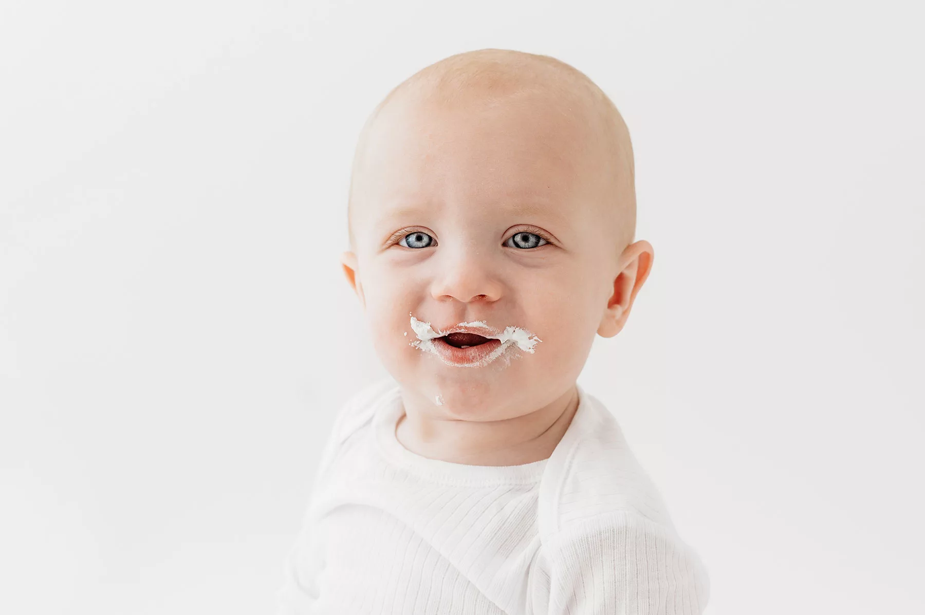 Baby boy cake smash photoshoot- big blue eyes with white romper