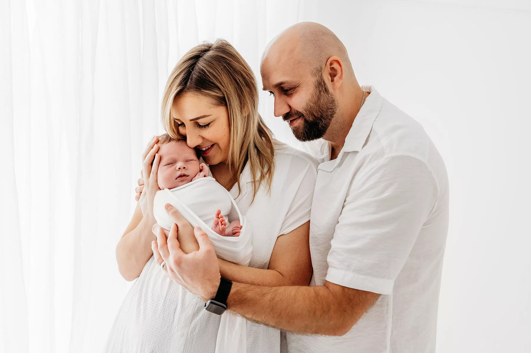 kent newborn photoshoot- mum and dad holding baby girl